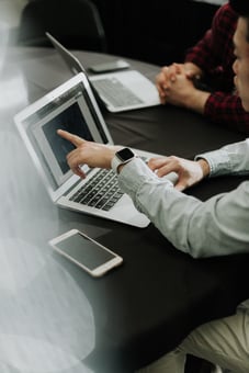 Imagen de compañeros de trabajo observando su trabajo en laptops.